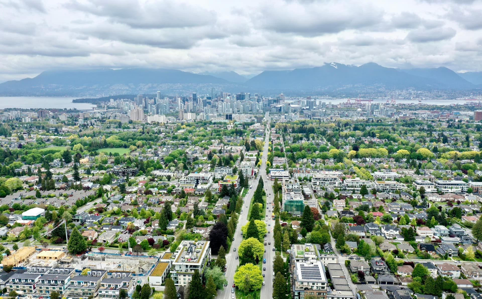 An aerial view of a residential neighbourhood with mountains in the distance