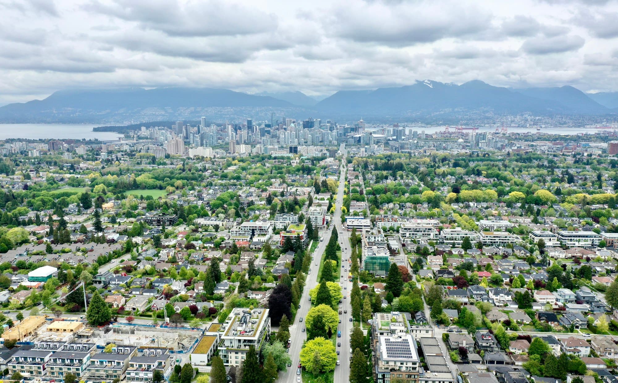 An aerial view of a residential neighbourhood with mountains in the distance