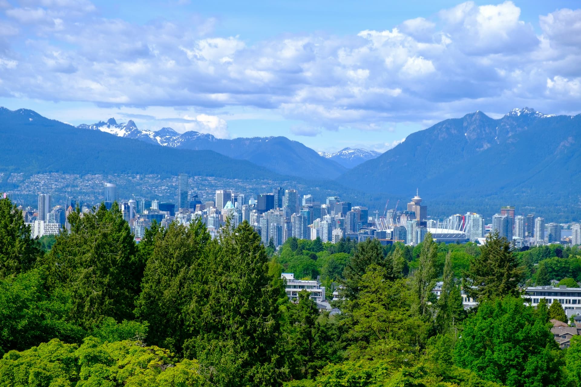 A West Coast city skyline framed by Coast Mountain peaks